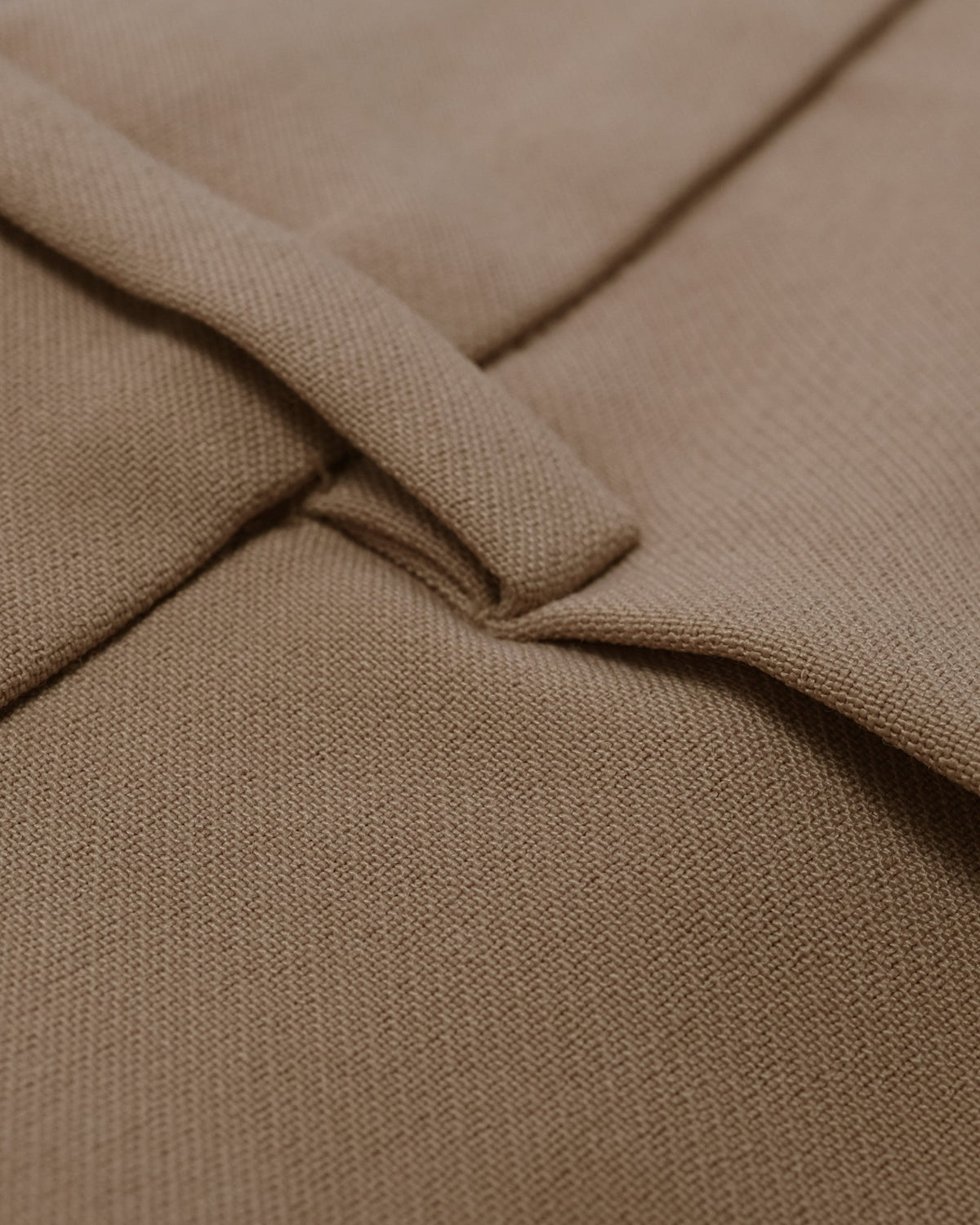 Close-up of beige fabric with a focus on texture and folds.