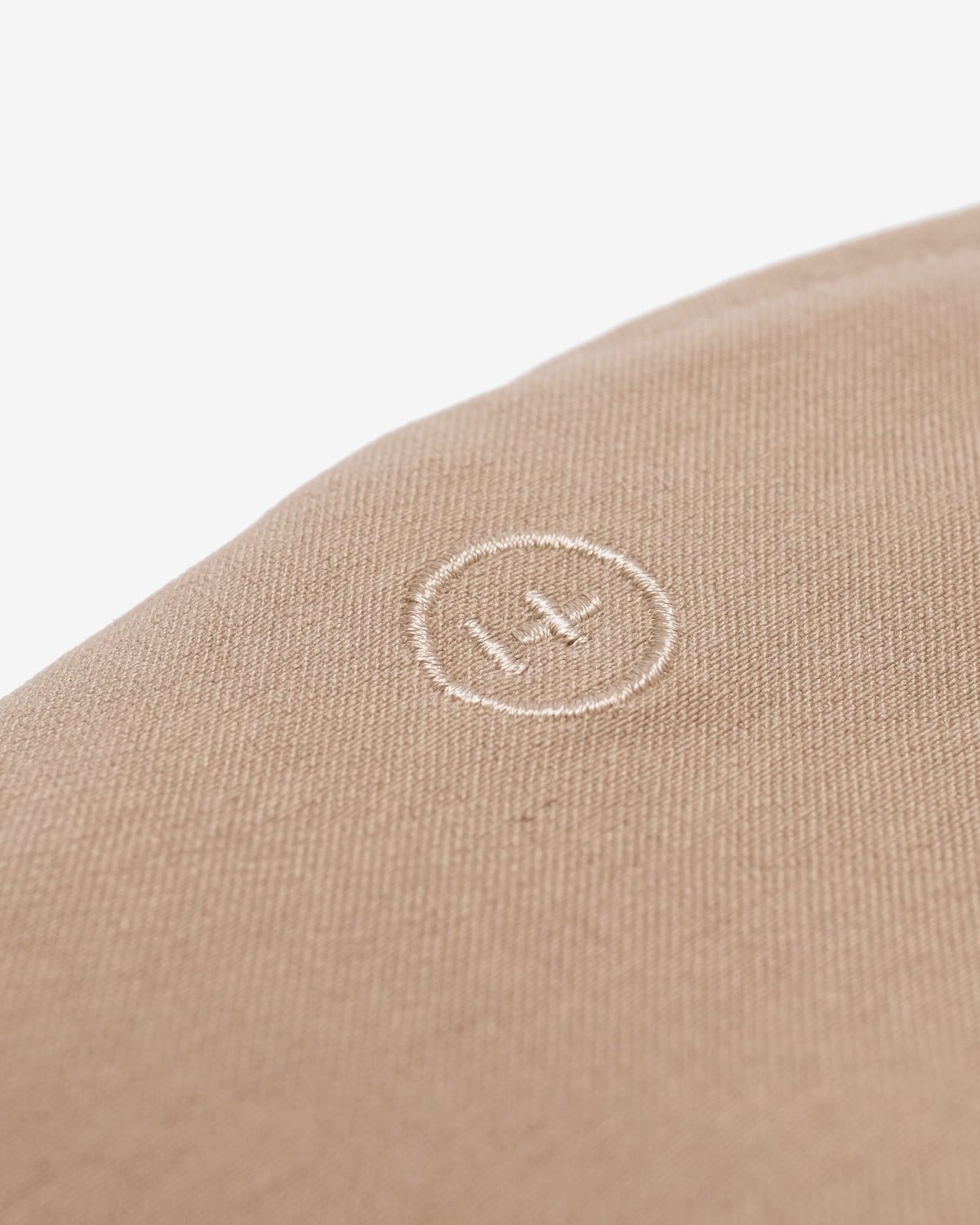 Close-up of a beige fabric with a logo on a white background
