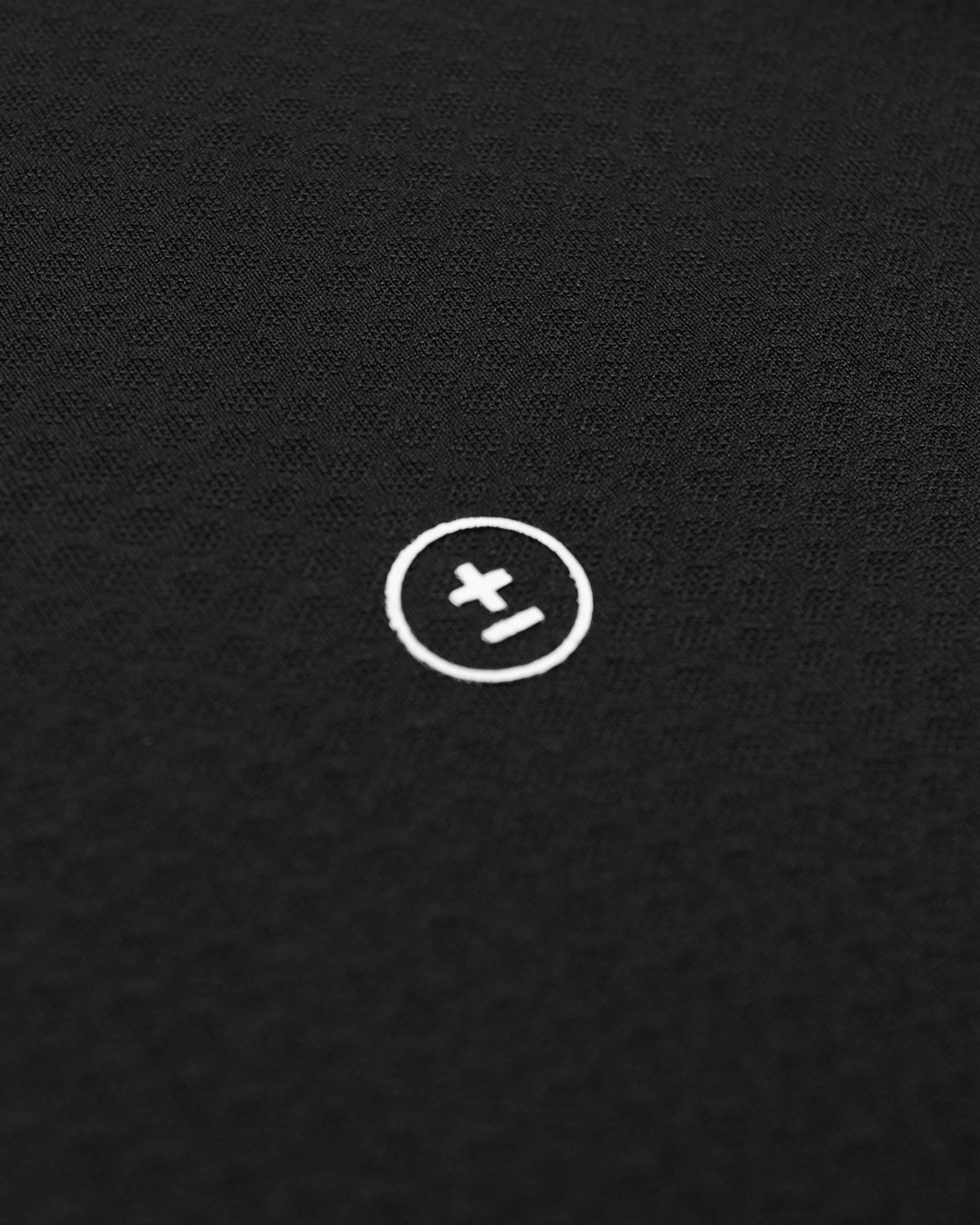 White circular logo with a plus sign on a black textured background