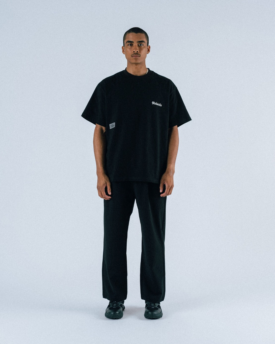 Person wearing a black t-shirt and pants on a white background