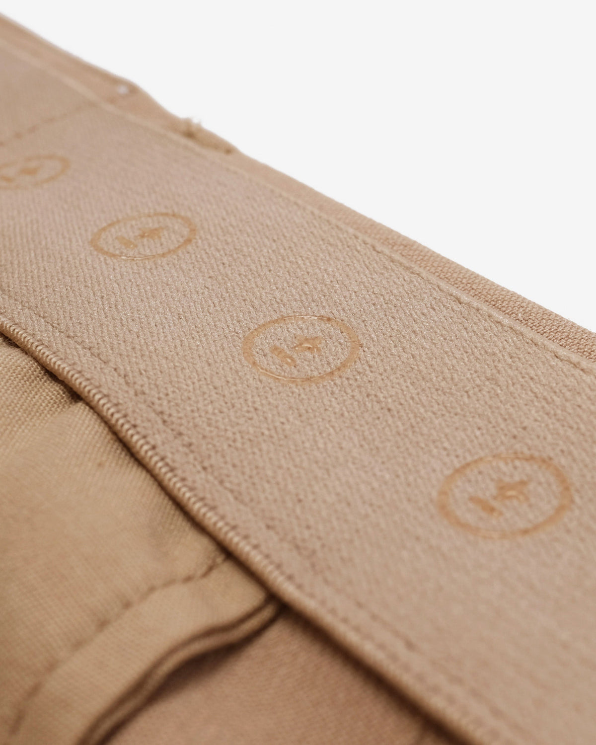 Close-up of beige fabric with circular patterns on a white background