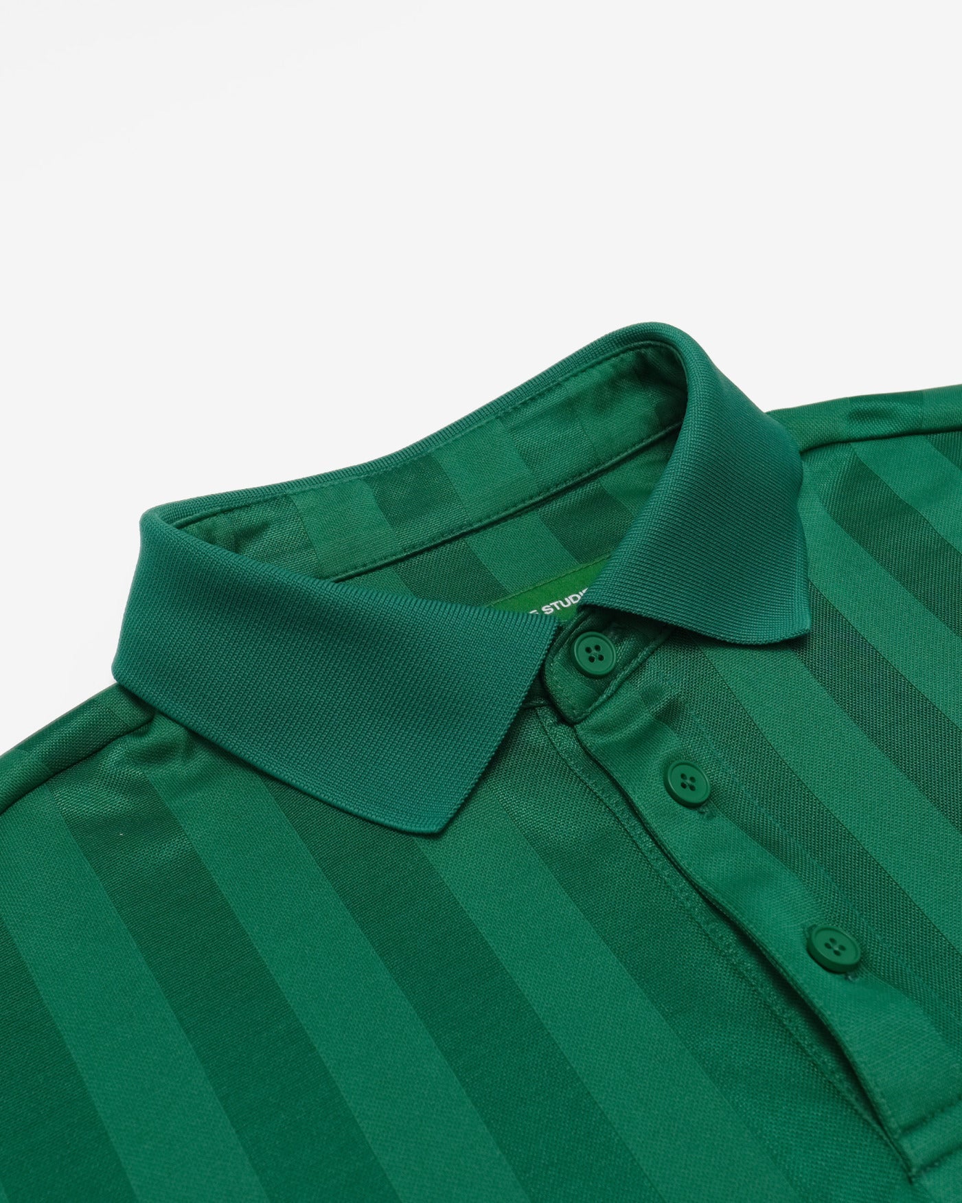 Green striped polo shirt with collar on a light gray background