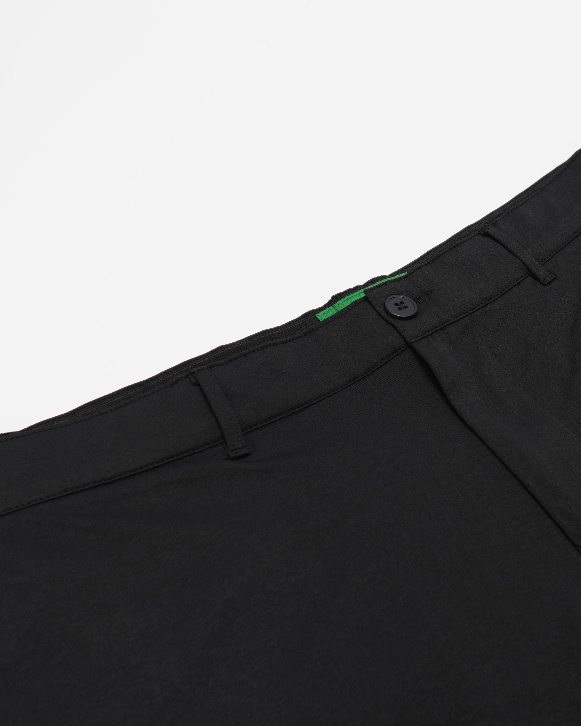Close-up of black pants with a button on a white background