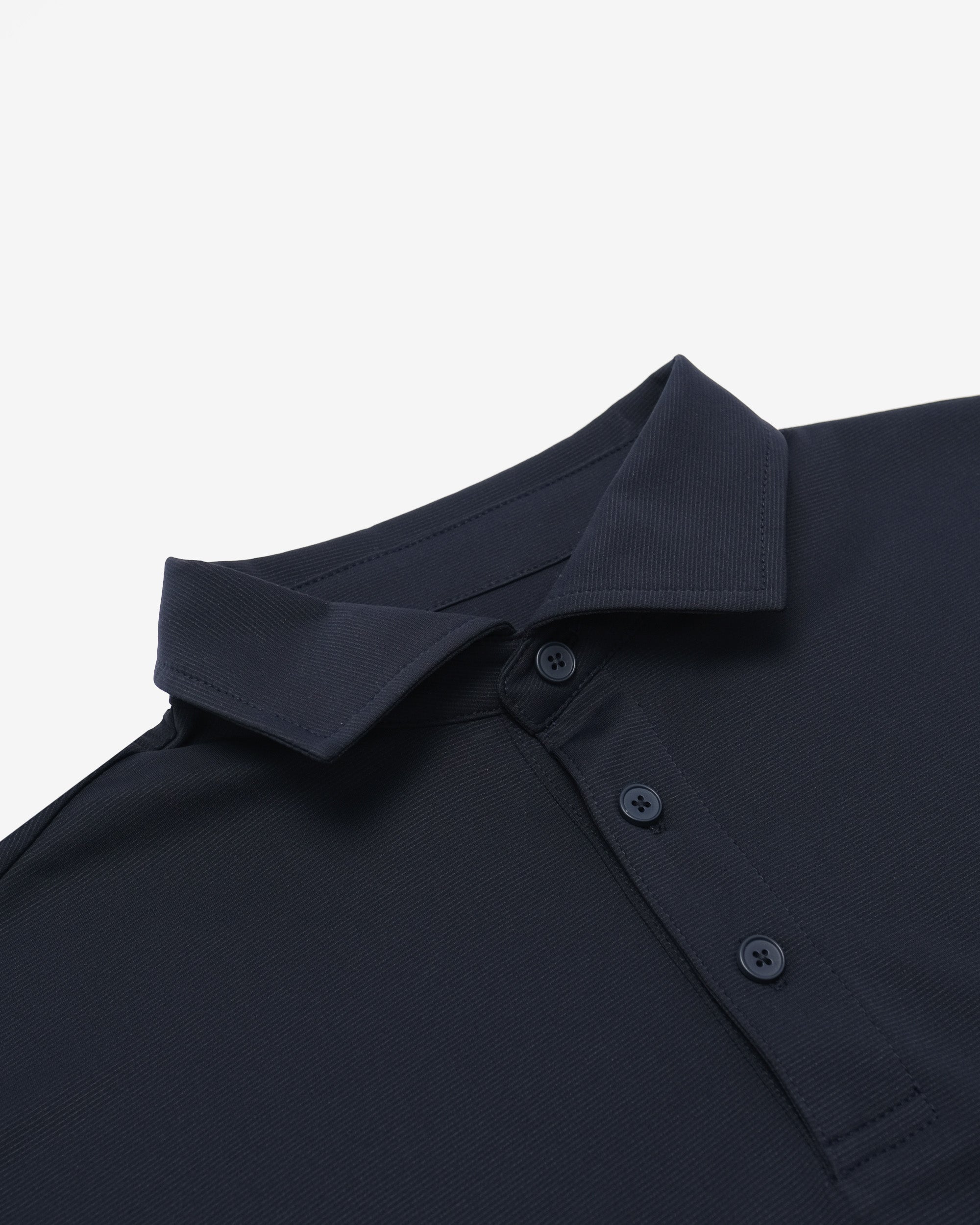Close-up of a dark blue polo shirt collar and buttons on a light gray background