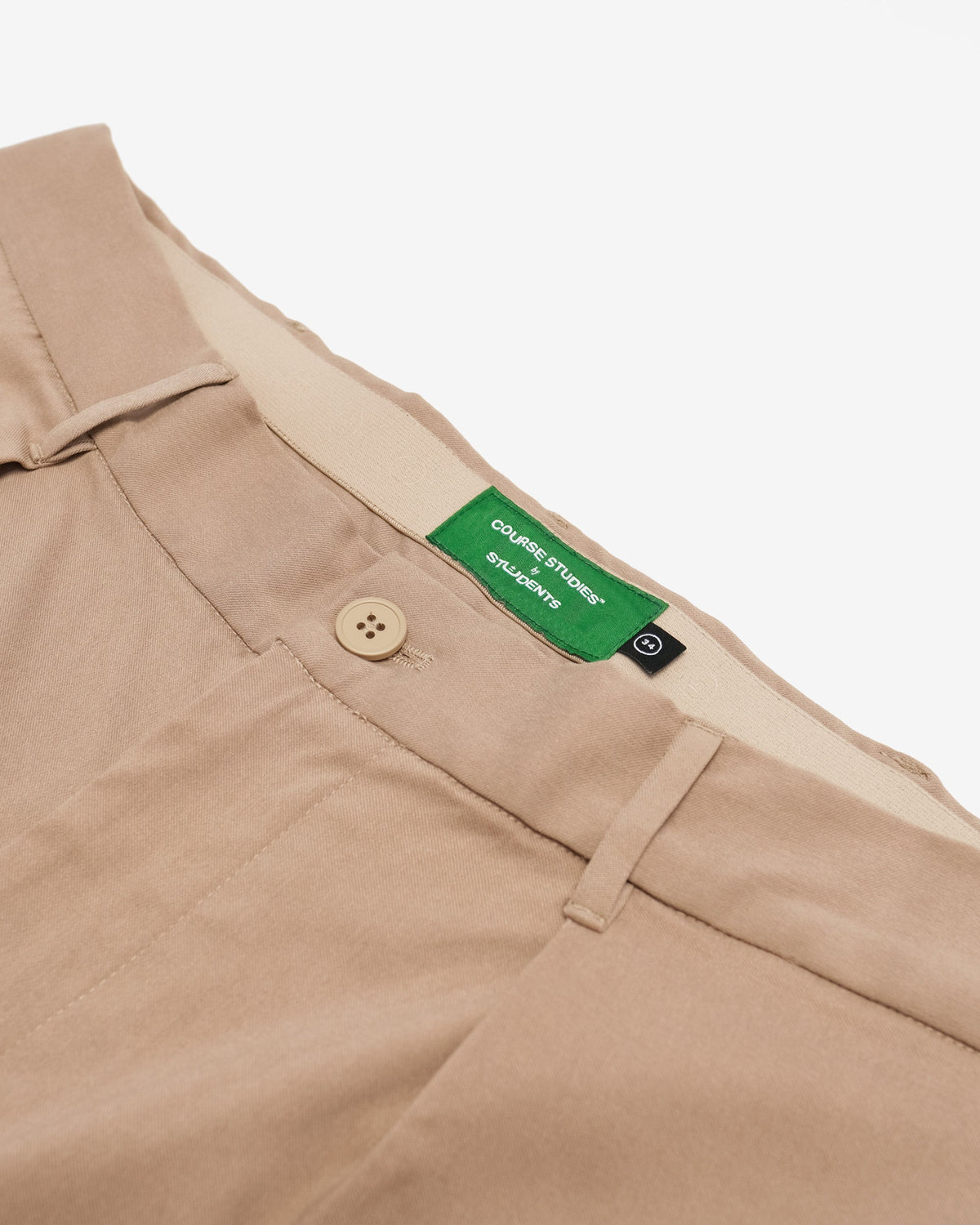 Beige pants with a green label on a white background