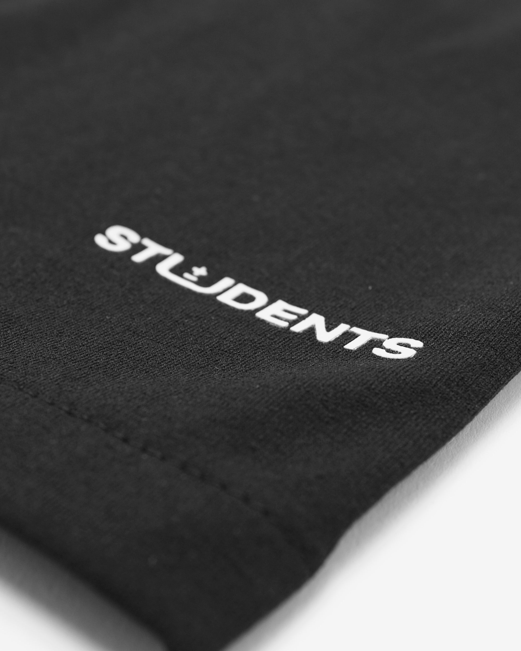 Black fabric with 'STUDENTS' embroidered in white on a white background